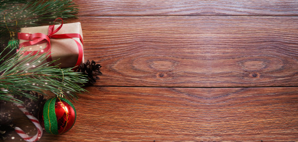 圣诞构图在一个黑色木制背景云杉树枝，礼物和玩具，星尘，俯视图。圣诞节。有文本空间。宽的照片。图片下载