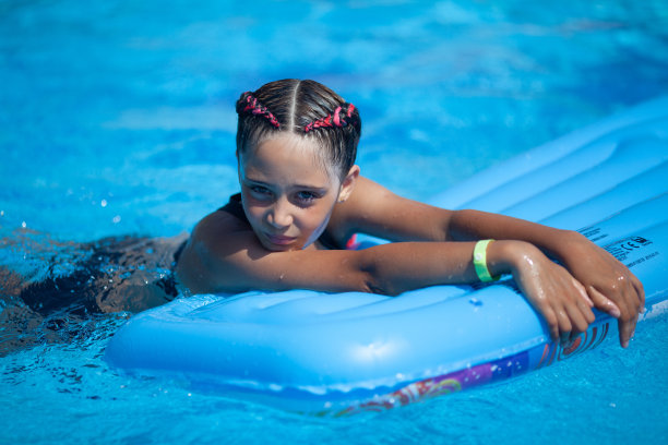 一个9岁的女孩在游泳池里游泳图片下载