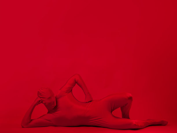 红色背景下的疯狂红人。穿着紧身连衣裤的身材图片下载