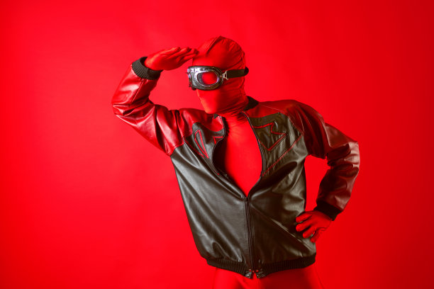 一个滑稽的超级英雄穿着红色紧身衣，戴着防护眼镜看着前方图片下载