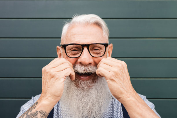 快乐的嬉皮士高级男子在城市户外的相机微笑-关注脸图片下载