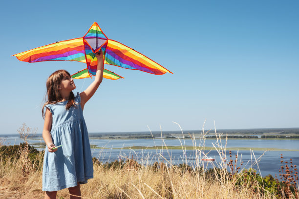 快乐的小女孩在大自然中玩风筝图片下载