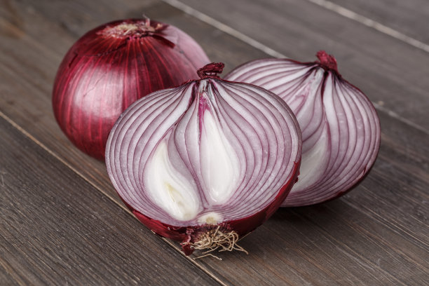 红洋葱在粗糙的木头上图片下载