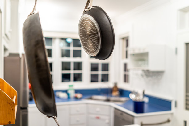 现代厨房挂盘和背景蓝色和白色法国乡村风格的房间，在晚上有窗户和台面图片下载