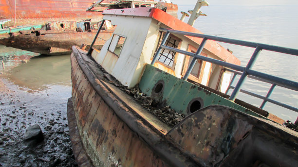 海滩边被遗忘的旧船图片下载