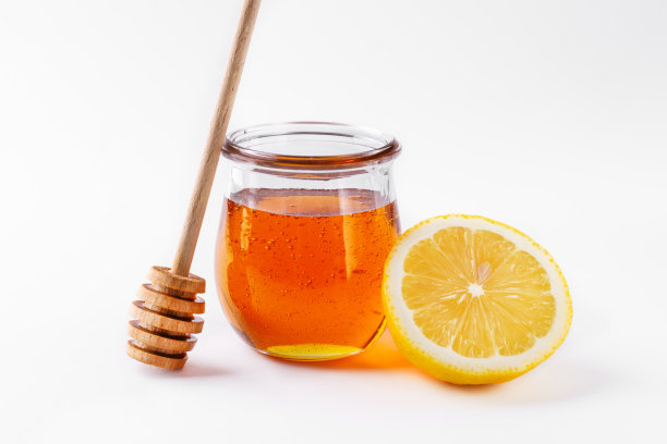 柠檬水果和蜂蜜装在白色背景的玻璃瓶里。图片下载