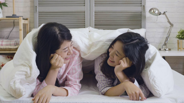 朋友们躺在床上用羽绒被盖住身体图片下载