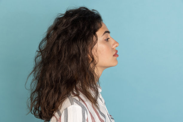 侧面的美丽的女孩，时尚的女模特与纹身在她的手孤立在浅蓝色的工作室背景。情感的概念，感觉图片下载