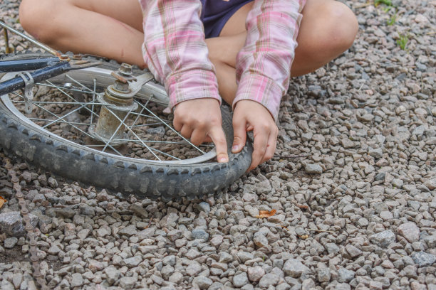 一个小女孩损坏了一个自行车轮子，正在修理照片没有处理图片下载