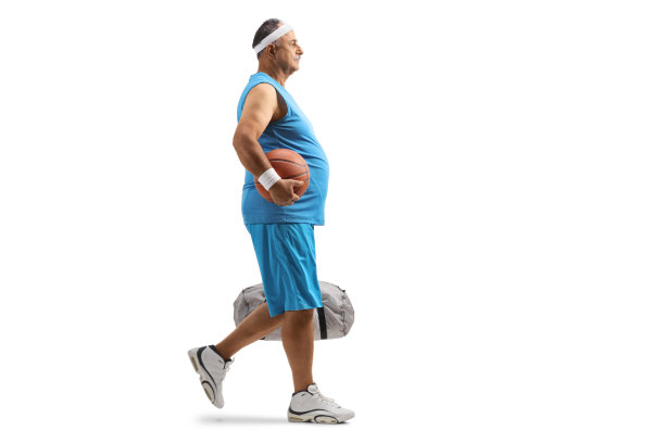 拿着篮球和运动包行走的中年男人全身照图片下载