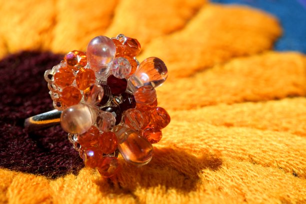 五颜六色的石头银戒指在织物背景图片下载