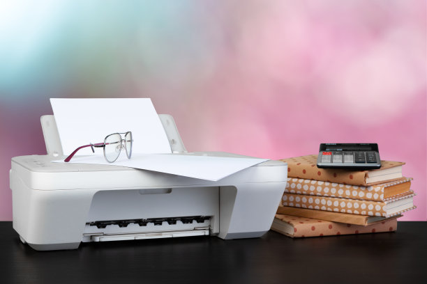 小巧的家庭打印机桌上与书籍模糊的背景图片下载