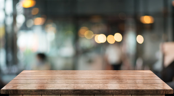 空木制桌面与灯光散景模糊餐厅背景。图片下载