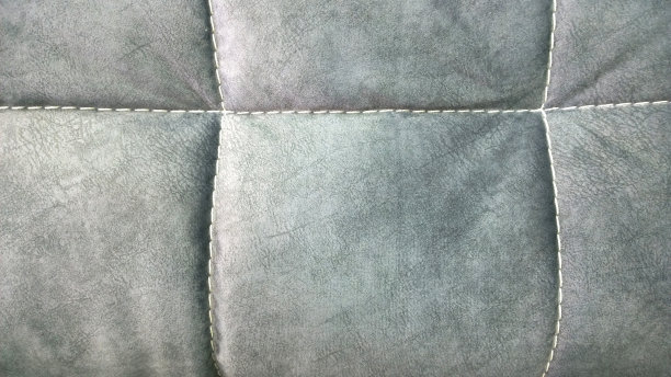 现代家具，椅子，扶手椅，沙发，坐垫或枕头的细节。灰色的颜色。生态皮革材料。织物。舒适的家。高端室内设计。垫装饰背景。关闭了。图片下载