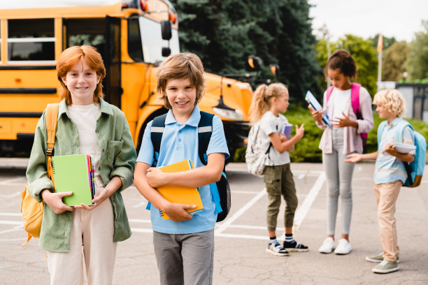 一群混血儿多民族的同学学生学童学童暑假后在校车旁交流交谈，讨论新的教育学期图片下载