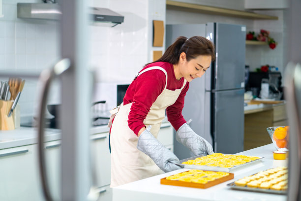 亚洲女人在厨房里烤挞面团。图片下载