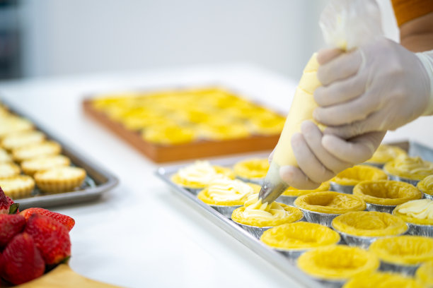 亚洲男子糕点厨师在厨房准备水果挞。图片下载