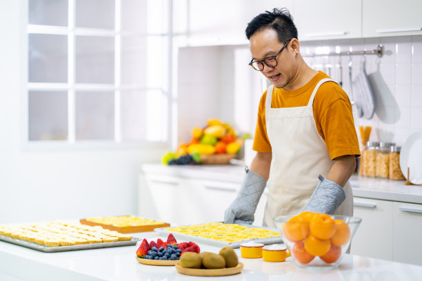 一个亚洲人在厨房里烤挞面团。图片下载