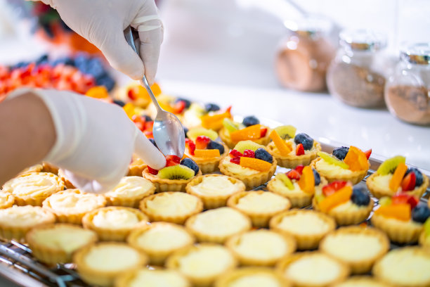 亚洲男子糕点厨师在厨房准备水果挞。图片下载