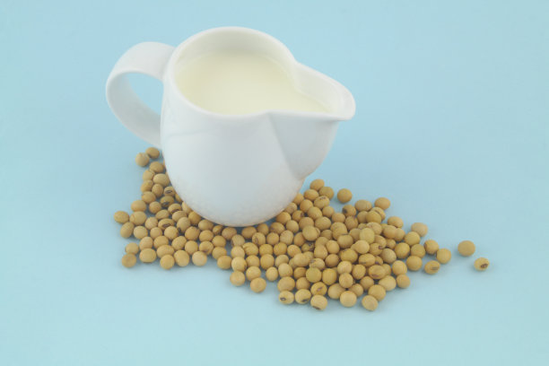 豆浆在罐子里，蓝色背景上有大豆图片下载