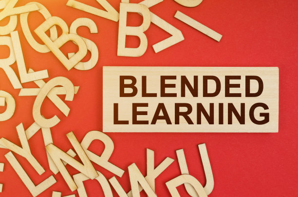 在红色的背景上，有木制的字母和一块刻有“混合学习”字样的板图片下载