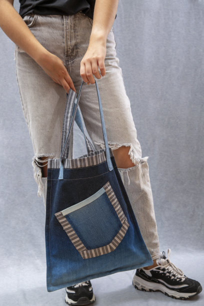女孩手里拿着牛仔布制成的可重复使用的环保袋图片下载
