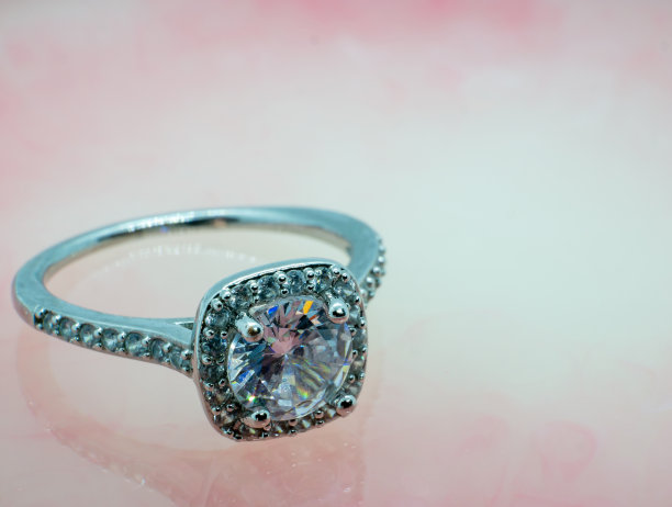 粉红色大理石上的银钻戒特写照片图片下载