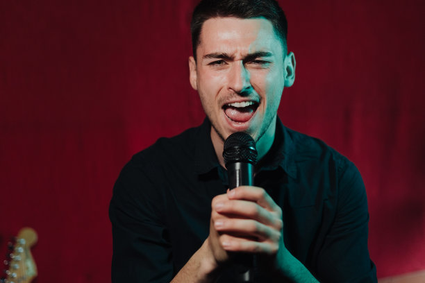 一个穿着皮夹克的人在俱乐部黑暗的舞台上表演图片下载