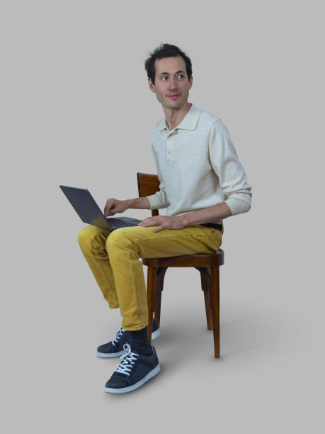 年轻人坐在椅子上用笔记本电脑图片下载