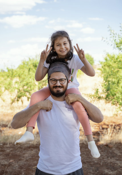 年轻的父亲背着他的女儿去野餐图片下载