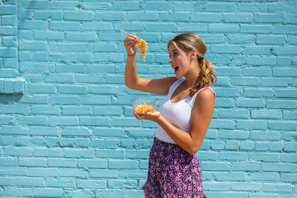 充满活力的少女拉面照片在工业商业区蓝色仓库墙明亮的背景照片系列图片下载