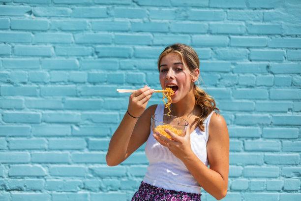 充满活力的少女拉面照片在工业商业区蓝色仓库墙明亮的背景照片系列图片下载