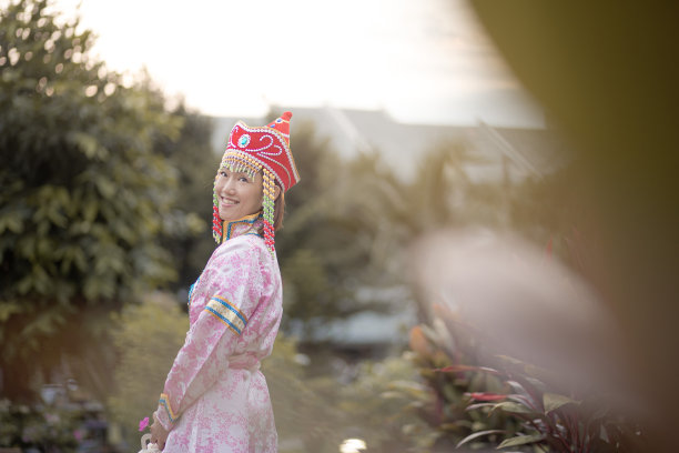 亚洲的中国成熟女性穿着传统服装，手拿月饼盒，在后院享受月饼节。图片下载