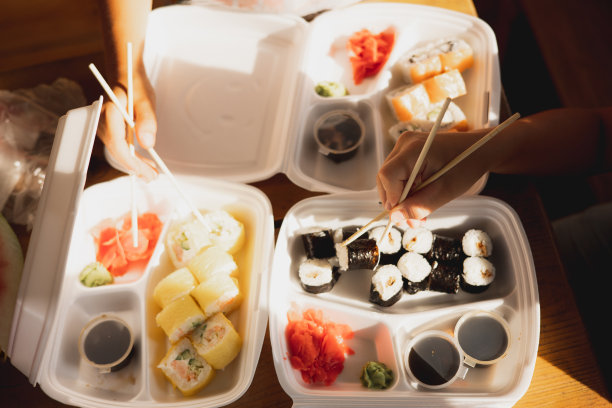 外卖寿司卷装在塑料食品容器中。日本料理。一套寿司卷在一次性容器。外卖服务和外卖概念图片下载