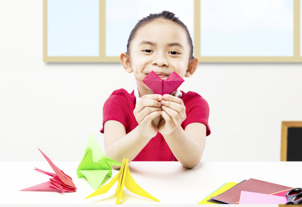 亚洲小女孩展示她的纸工艺品图片下载