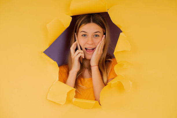 年轻女子在打电话时看起来很震惊。图片下载