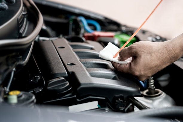 家庭服务汽车概念:一个人检查发动机油的水平和看到污渍从使用基本保养的汽车图片下载