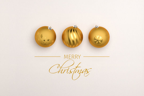 在纸背景上的三个金色圣诞小玩意。在下面留言“圣诞快乐”。图片下载