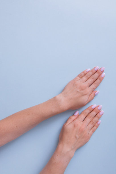 时尚时尚的女性美甲。美丽年轻女子的手放在蓝色背景上。图片下载