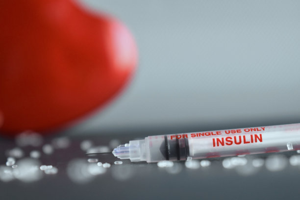 聚焦胰岛素注射器，背景为心形盒子。图片下载