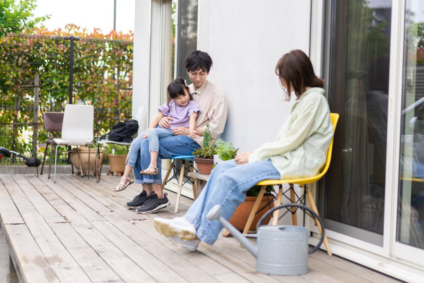 一个女孩和她的家人在家里的花园里放松图片下载