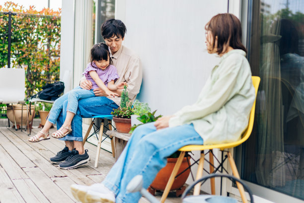 一个女孩和她的家人在家里的花园里放松图片下载