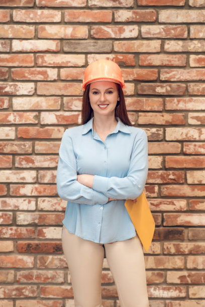 快乐的女人在砖墙背景上图片下载