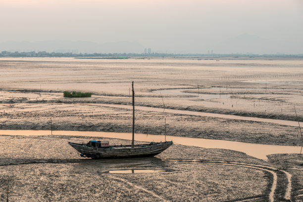黄昏时分，被遗弃的渔船停泊在浅滩上图片下载