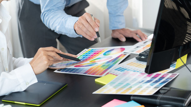 图形设计师团队工作在网页设计使用色板编辑艺术作品使用平板电脑和笔在办公桌在创意办公室。图片下载