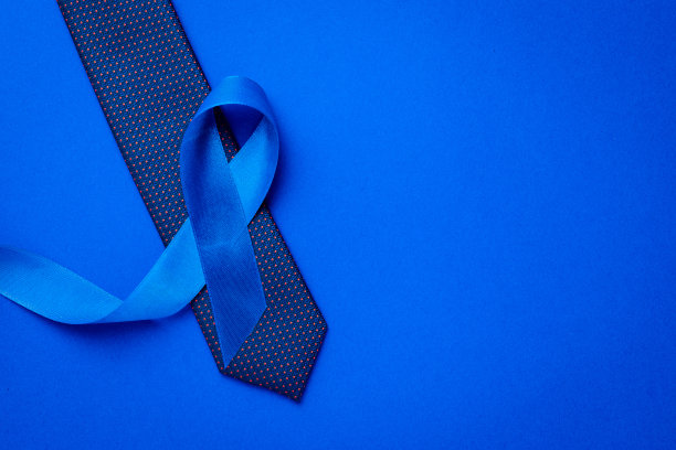 癌症的认识蓝色。蓝色丝带，时尚领带孤立在深蓝色背景。11月前列腺癌男性健康意识。11月和国际男人节。图片下载
