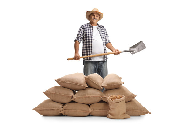 中年农民手持铁锹与麻袋堆合影图片下载