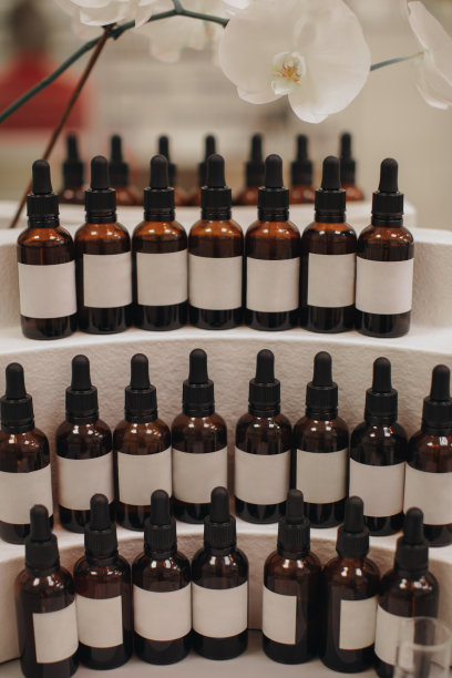 实物化妆面部精华液棕色玻璃瓶与吸管时尚简约的背景与花卉装饰。图片下载