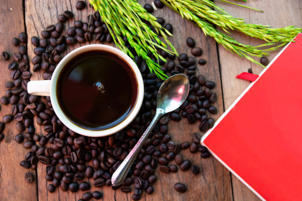 咖啡杯豆和笔记本放在旧木地板上图片下载