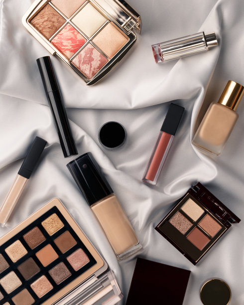 集专业精英装饰彩妆于一身的白色绸布。纺织品的背景。副本的空间。美与时尚的概念。化妆品美容产品:口红、眼影、粉底图片下载